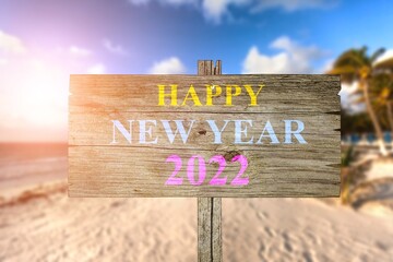 Hapy new year 2022 written on direction signs, beach background, travel and tourism greeting card