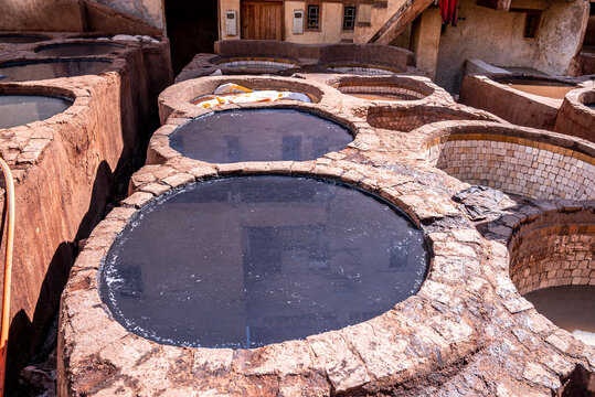 Brims of old stone water baths with colorful dyes used for traditional dyeing of leather