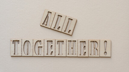 the expression "all together" in wooden stencil font on paper