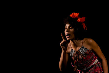 Actress on stage represents a dramatic character. She is standing.