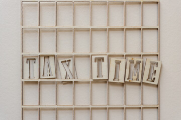 the expression "tax time" in wooden stencil font on paper