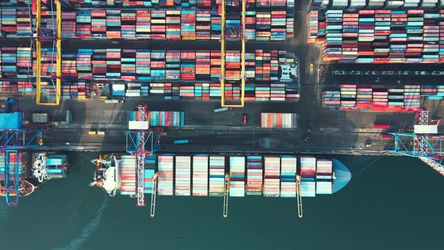 December, 2021 - Vladivostok, Russia - Vladivostok Commercial Sea Port. View from above. Fast shooting. Time laps. Loaders drive between containers while loading onto a merchant ship. 