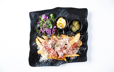 Fried potatoes with pepper cheese in a square plate