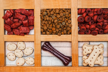 Pet food, snacks for dogs. Dog tasty colored biscuits on wooden background
