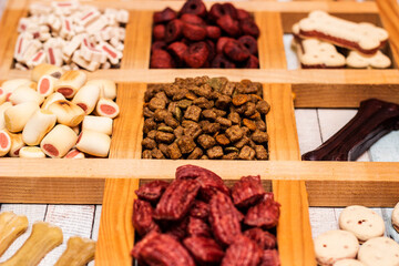 Pet food, snacks for dogs. Dog tasty colored biscuits on wooden background