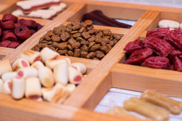 Pet food, snacks for dogs. Dog tasty colored biscuits on wooden background