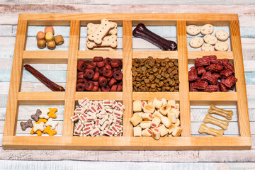 Pet food, snacks for dogs. Dog tasty colored biscuits on wooden background