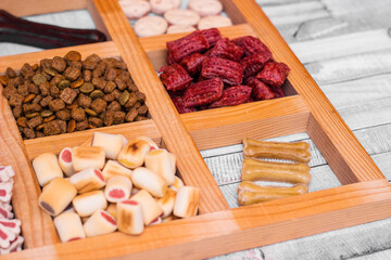 Pet food, snacks for dogs. Dog tasty colored biscuits on wooden background