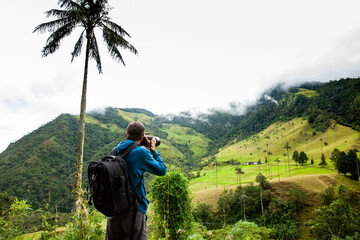Tourist taking pictures at the beautiful Valle de Cocora located in Salento at the Quindio region in Colombia - obrazy, fototapety, plakaty