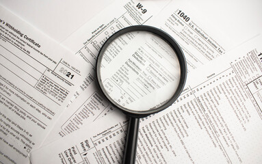 Tax Form 1040 with magnifying glass. Tax concept