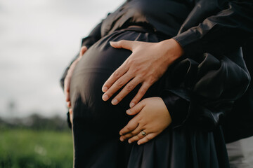 pregnant couple holding hands together