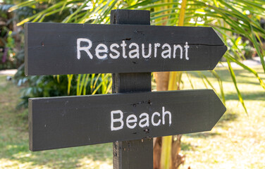 Sign at a resort pointing to restaurant and beach