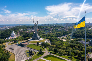 Aerial view of the Ukrainian flag waving in the wind against the city of Kyiv, Ukraine near the...