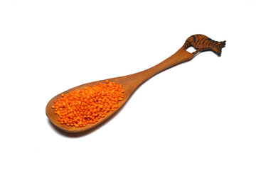 red lentils in wooden spoon isolated on white background. Top view.	
