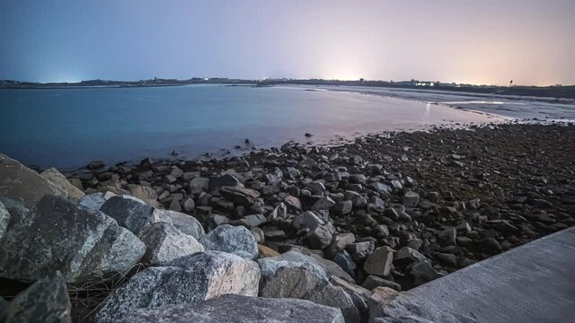 View of low high tides in timelapse by the coast of Guernsey Island in the English Channel off the coast of Normandy that is part of the Bailiwick of Guernsey at sunrise.