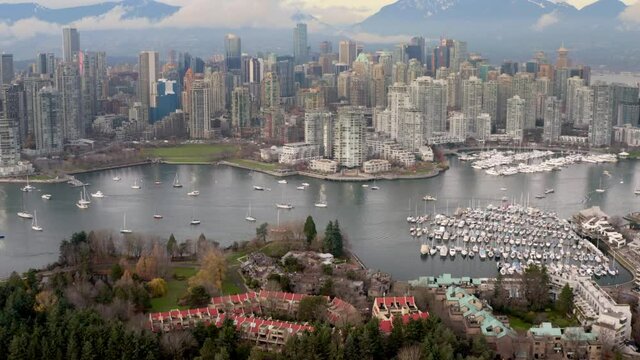Boats Dock At Heather Civic Marina With Downtown Vancouver Skyline At Sunrise In British Columbia, Canada. - aerial tilt up