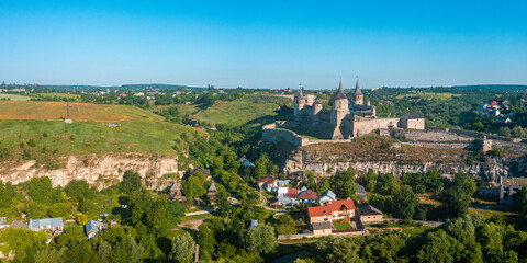 Aerial view of the romantic stone medievel castle on top of the mountain during sunny summer day.