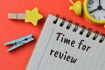 Clothespins and notebook written with text TIME FOR REVIEW