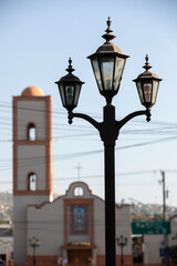 Fototapeta na wymiar Tecate, Baja California, Mexico - September 14, 2021: Late afternoon light shines on historic downtown street lights.