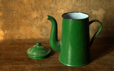 Antique enameled green coffee pot on a wooden table. vintage kitchen items.
