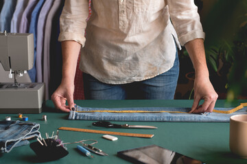 Seamstress measuring jeans length for hemming