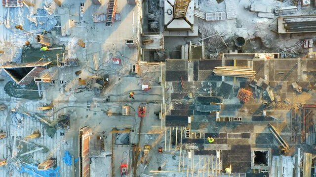 Aerial top down view of builders lay formwork for pouring concrete for a new floor of a building under construction