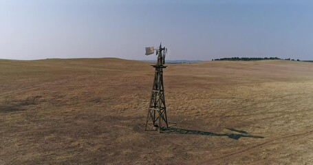 Old windmill in a field of bison on the great plains
