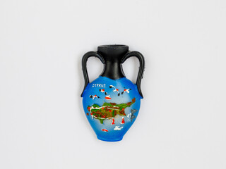Fridge magnet souvenir from Greece (island of Cyprus) in shape of amphora with inspiration Cyprus and map of island on white background. Travel to Cyprus concept. Top view flat lay close up.