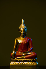 Lord Budhha Statue Golden and Red colour. Black Background and lit statue with lights