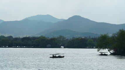 Obraz premium The beautiful lake landscapes in the Hangzhou city of the China in spring with the peaceful lake and fresh green mountains