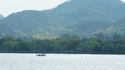 Fototapeta na wymiar The beautiful lake landscapes in the Hangzhou city of the China in spring with the peaceful lake and fresh green mountains