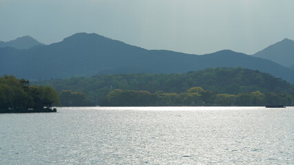 The beautiful lake landscapes in the Hangzhou city of the China in spring with the peaceful lake and fresh green mountains