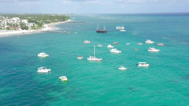 Boats anchored in turquoise Caribbean sea just off tropical beach in Los Corales