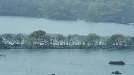 The beautiful lake landscapes in the Hangzhou city of the China in spring with the peaceful lake and fresh green mountains