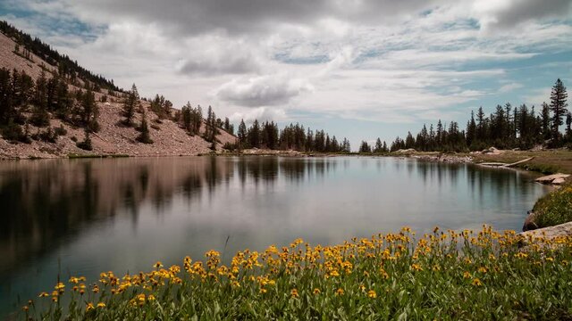 A time-lapse of clouds passing over Johnson Lake, an alpine lake in the Snake Range, located inside Great Basin National Park in Nevada, as seen on a summer day. Yellow flowers line the lakeshore.