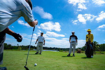 Group of Asian people businessman and senior CEO golfing near the hole on golf fairway together at...