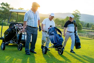 Poster  Group of Asian people businessman and senior CEO enjoy outdoor sport golfing together at country club. Healthy men golfer holding golf bag walking on fairway with talking together at summer sunset © CandyRetriever 
