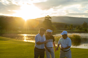 Group of Asian people businessman and senior CEO shaking hand after finish talking business project and game on golf course. Male golfer enjoy outdoor sport lifestyle golfing together at country club.