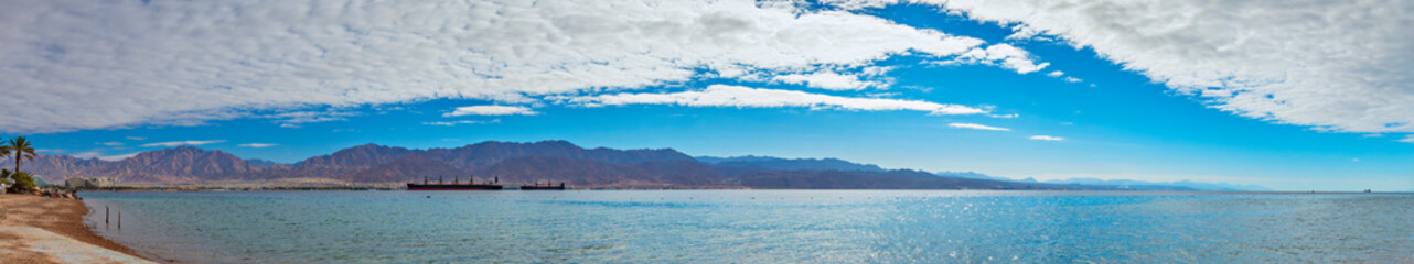 Fototapeta na wymiar Panoramic view on the Red Sea from a beach near Eilat - famous tourist resort and recreational city in Israel