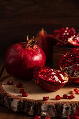 Obraz na płótnie Canvas Red ripe pomegranates on a wooden background. The cut fruits of the pomegranate tree.