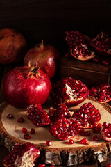 Red ripe pomegranates on a wooden background. The cut fruits of the pomegranate tree.