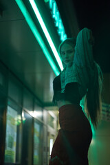 Portrait of a Young Woman at Night in Neon Light. High quality photo