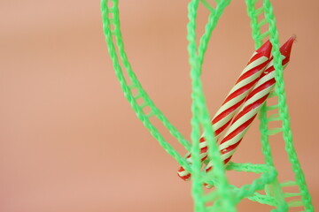 Colourful candles isolated in the green rope on pink background. Birthday,Christmas and special greetings concept. © Hari