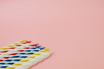 Colourful candles isolated in the green rope on pink background. Birthday,Christmas and special greetings concept. © Hari