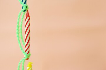 Colourful candles isolated in the green rope on pink background. Birthday,Christmas and special greetings concept.