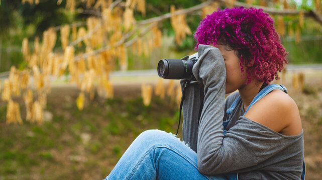 Girl who is dedicated to photography prepares from home to go to take photos of nature.
