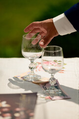 a waiter puts two big glasses of wine on the table.
