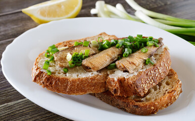 Smorrebrod with sprats, butter and green onions. Close-up.