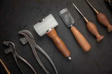 Set of leather craft cobbler tools on black background