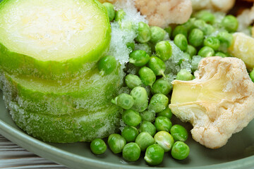 Close-up frozen peas, zucchini, cauliflower in plate